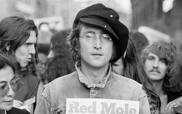Portrait of British musician John Lennon and his wife, artist and musician Yoko Ono (extreme left) as they attend an unspecified rally in Hyde Park, London, England, 1975.